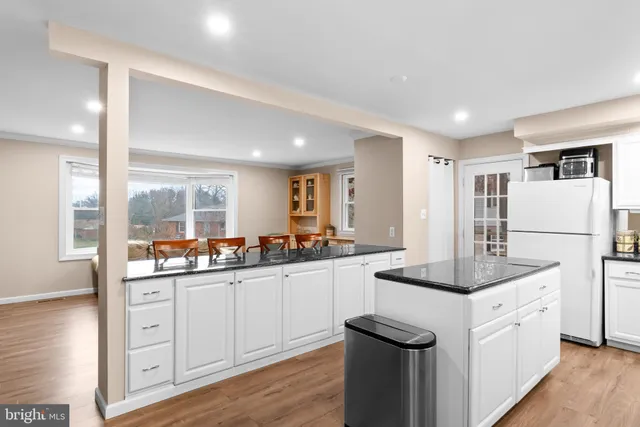 a kitchen with granite countertop a sink stove and refrigerator