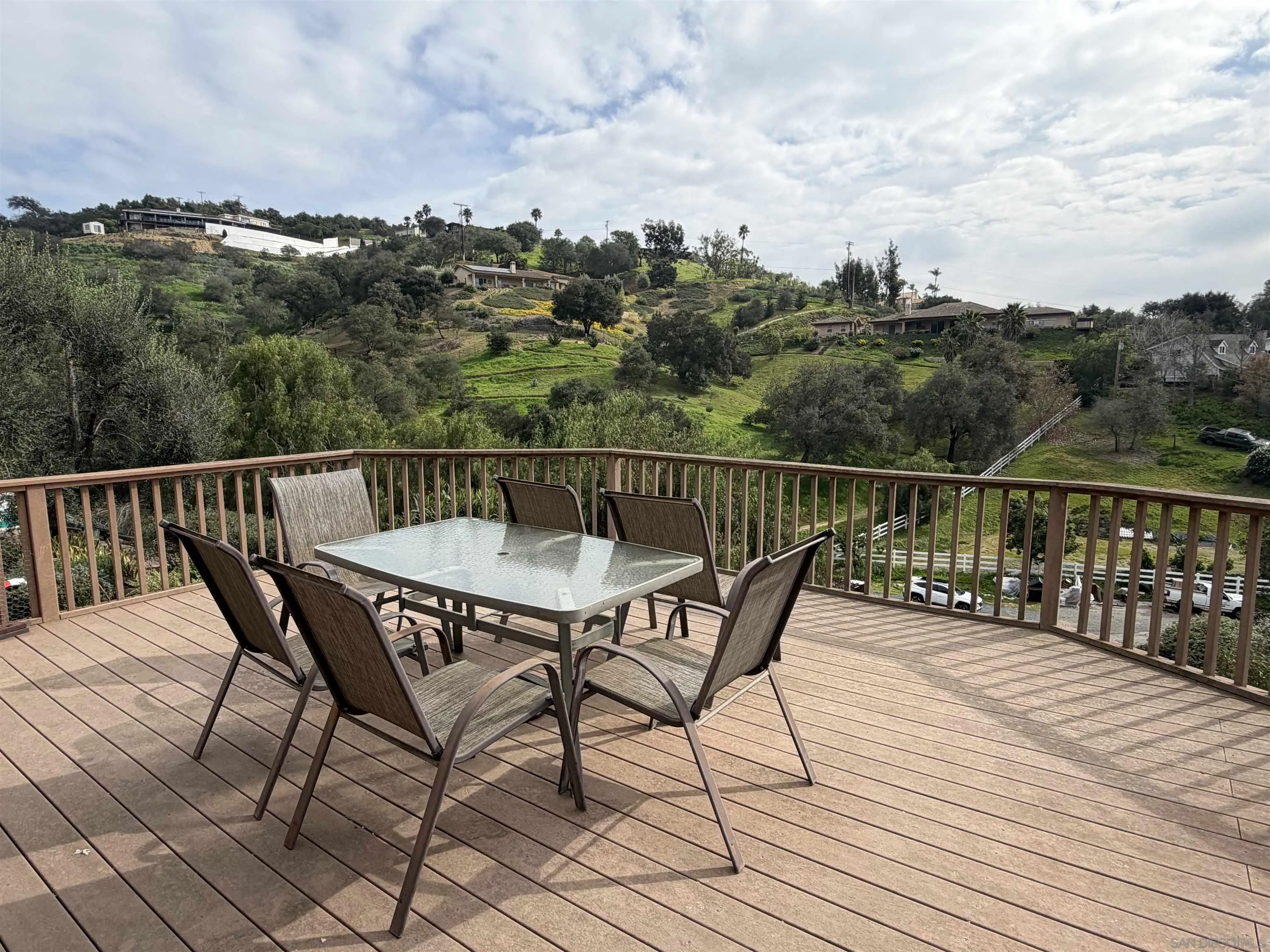 2416 Gird Road Fallbrook, CA 92028 - Photo 2 of 17 a view of a roof deck with table and chairs and wooden floor