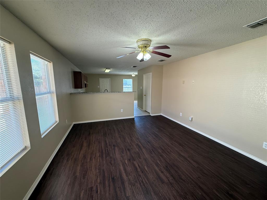 7541 Marietta Lane Dallas, TX 75241 - Photo 3 of 10 a view of an empty room with wooden floor and a window