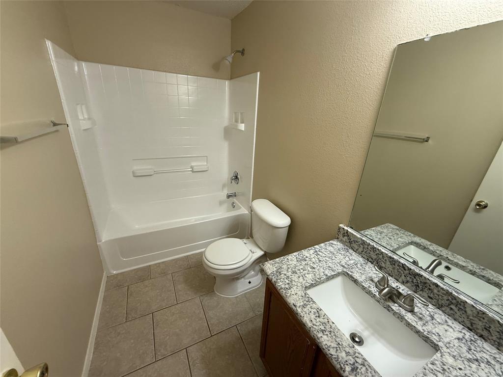 7541 Marietta Lane Dallas, TX 75241 - Photo 6 of 10 a bathroom with a granite countertop sink a toilet and shower