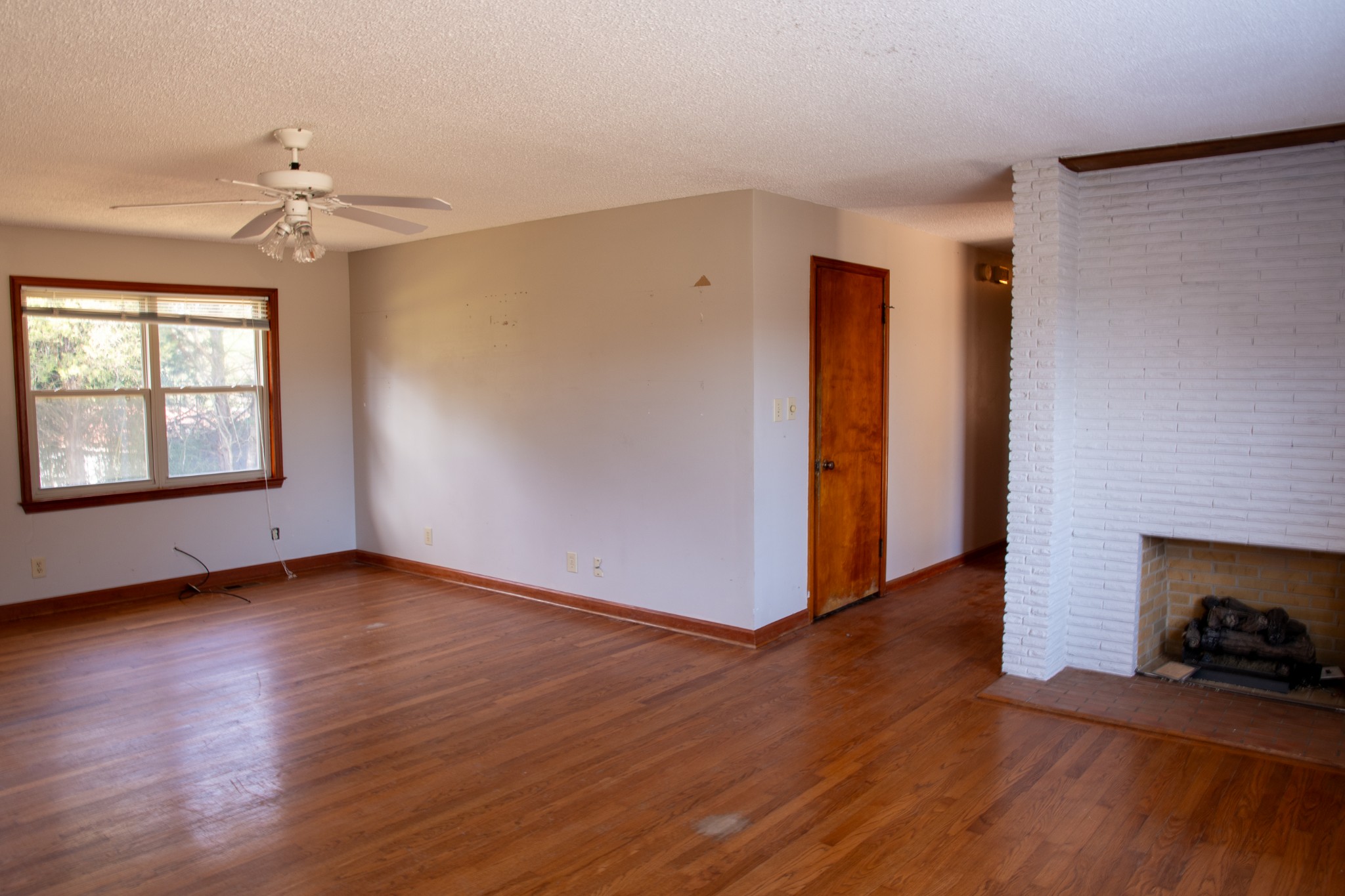 340 Jeff Road Northwest Huntsville, AL 35806 - Photo 6 of 18 an empty room with wooden floor fireplace and windows