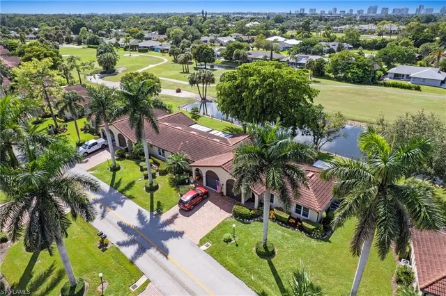 an aerial view of residential houses with outdoor space and trees