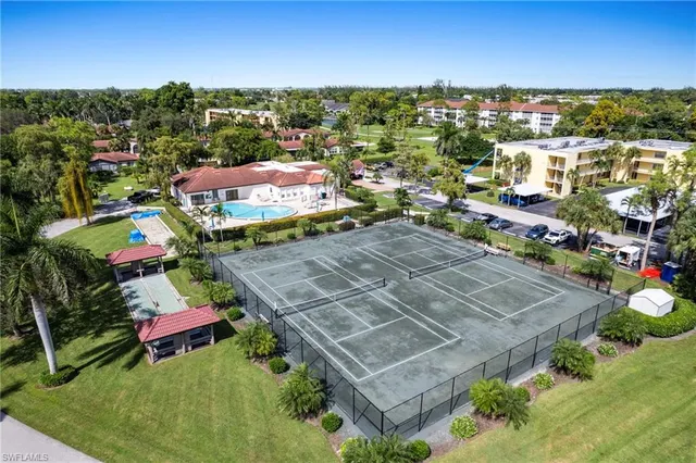 an aerial view of residential houses with outdoor space and trees