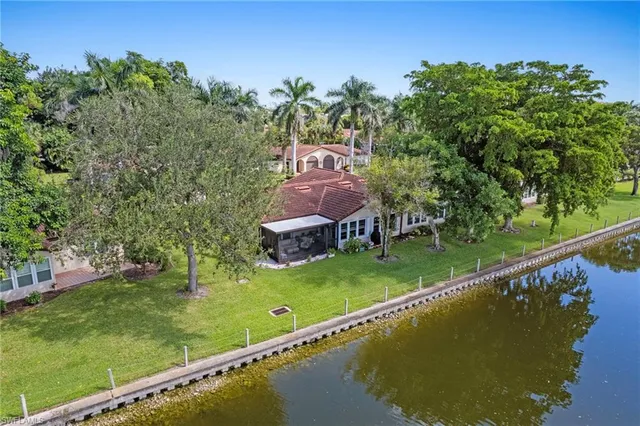 an aerial view of a house with a garden and lake view
