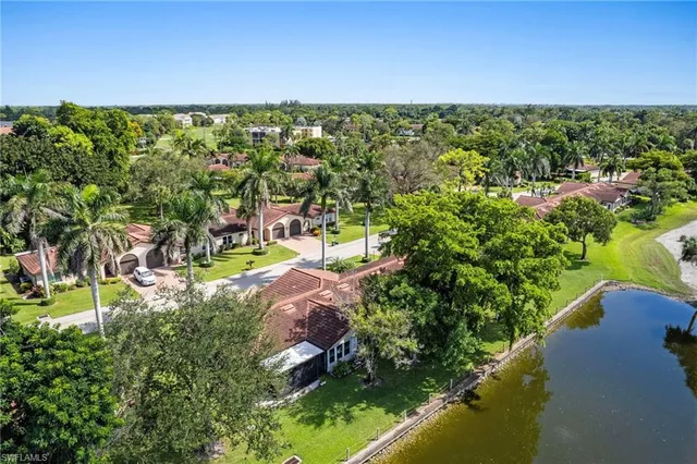 an aerial view of a city with lots of residential buildings ocean and mountain view in back