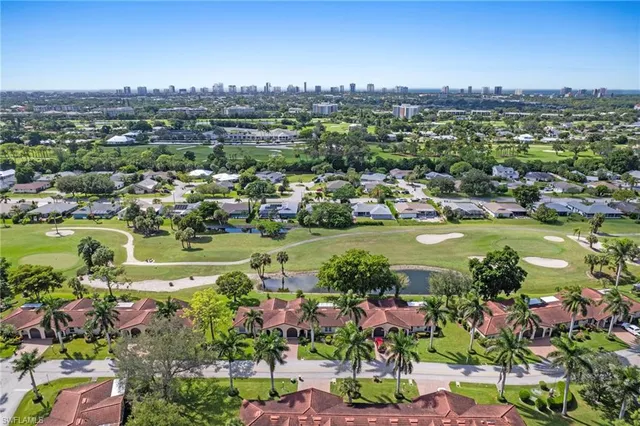 an aerial view of residential houses with outdoor space and trees