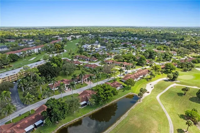 an aerial view of residential houses with outdoor space and trees