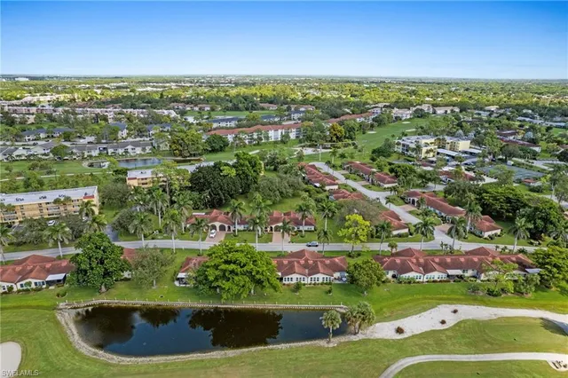 an aerial view of residential houses with outdoor space and trees