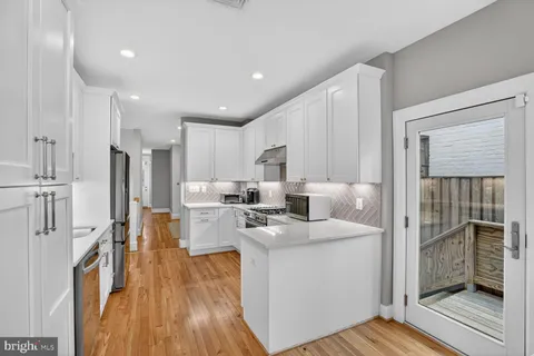 a kitchen with a refrigerator and a stove top oven