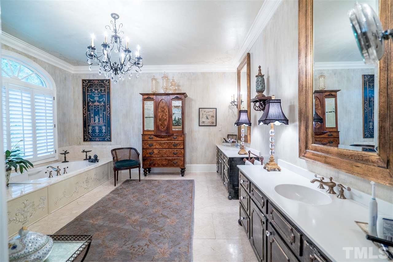 9904 Mathias Court Raleigh, NC 27615 - Photo 12 of 25 a spacious bathroom with a double vanity sink double vanity granite tub and a mirror