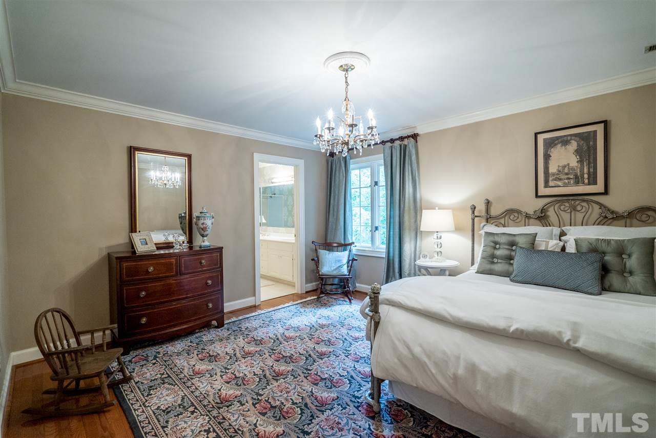 9904 Mathias Court Raleigh, NC 27615 - Photo 15 of 25 a spacious bedroom with a bed and a mirror on dresser