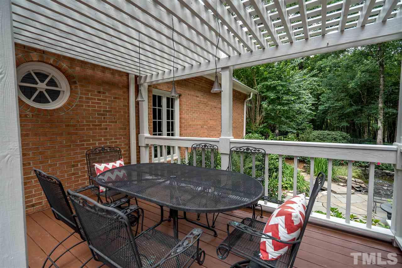 9904 Mathias Court Raleigh, NC 27615 - Photo 20 of 25 a view of a balcony with table and chairs and wooden fence