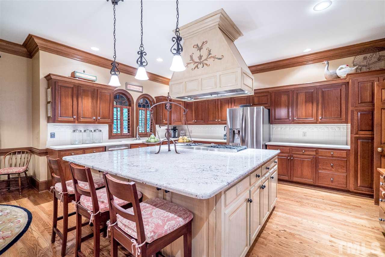 9904 Mathias Court Raleigh, NC 27615 - Photo 6 of 25 a kitchen with a sink a stove and chairs