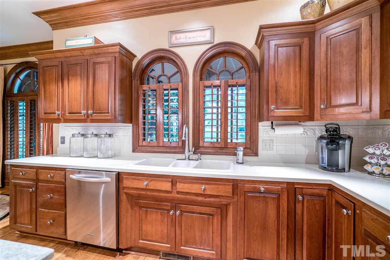 9904 Mathias Court Raleigh, NC 27615 - Photo 8 of 25 a kitchen with stainless steel appliances granite countertop a sink and cabinets with wooden floor