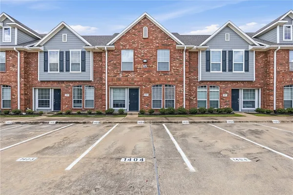 front view of a brick house with a yard