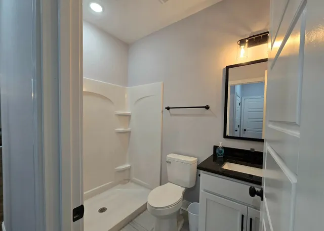 a bathroom with a toilet a sink and mirror