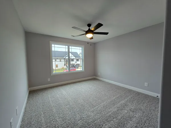 an empty room with windows and ceiling fan