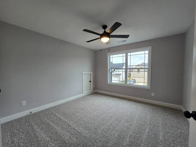 a view of room with a ceiling fan and window