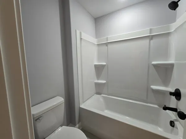 a white bath tub sitting next to a white toilet and sink