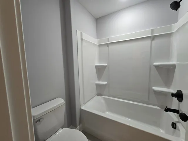 a white bath tub sitting next to a white toilet and sink