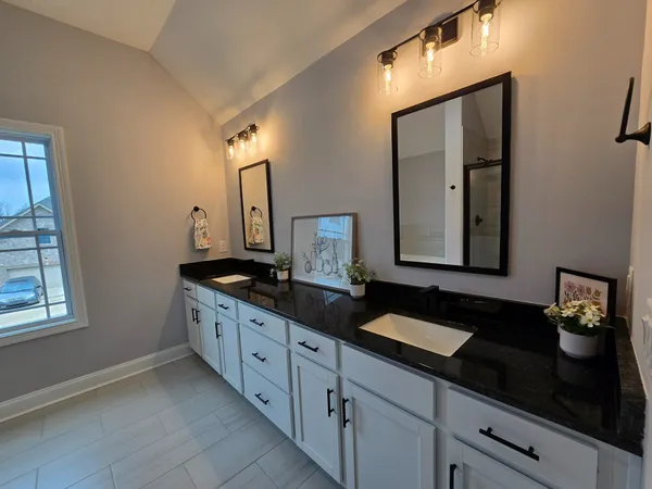 a bathroom with double sink and a mirror