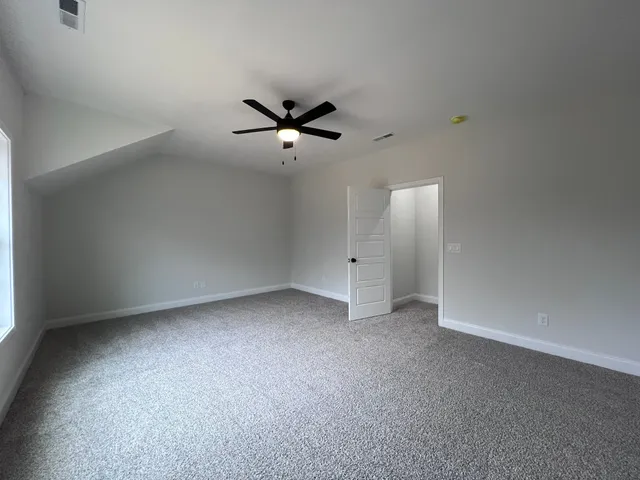 an empty room with a ceiling fan and a window