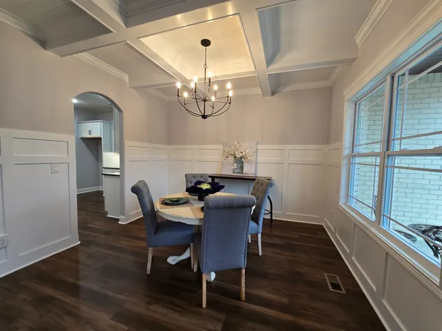 a view of a dining room with furniture a chandelier and wooden floor