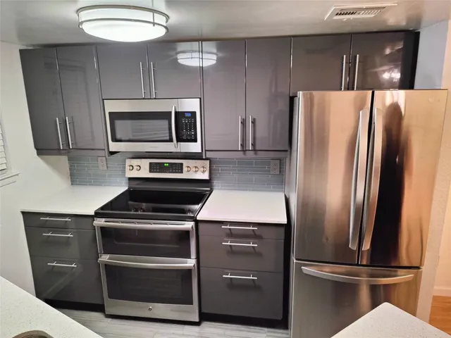 a metallic refrigerator freezer sitting in a kitchen