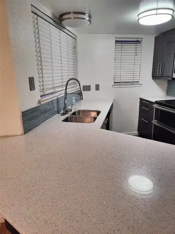 a kitchen with a sink and a stove top oven