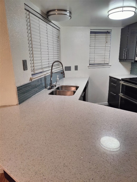 2500 Burleson Road, Unit 315 Austin, TX 78741 - Photo 4 of 21 Kitchen with light, quartz countertops, dark European style cabinets, and tasteful backsplash