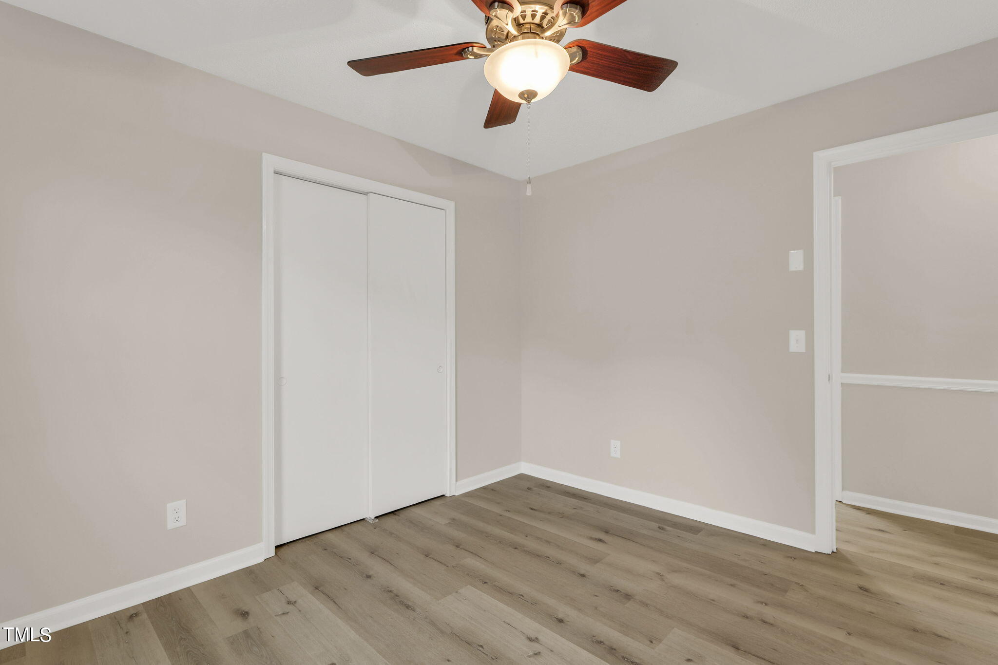 1073 Brick Mill Road Coats, NC 27521 - Photo 16 of 32 an empty room with wooden floor chandelier fan and closet area