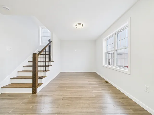 a view of entryway and hall with wooden floor