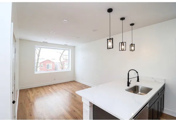 an empty room with wooden floor and a ceiling fan