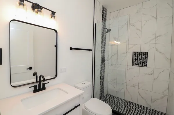 a bathroom with a sink a toilet and shower