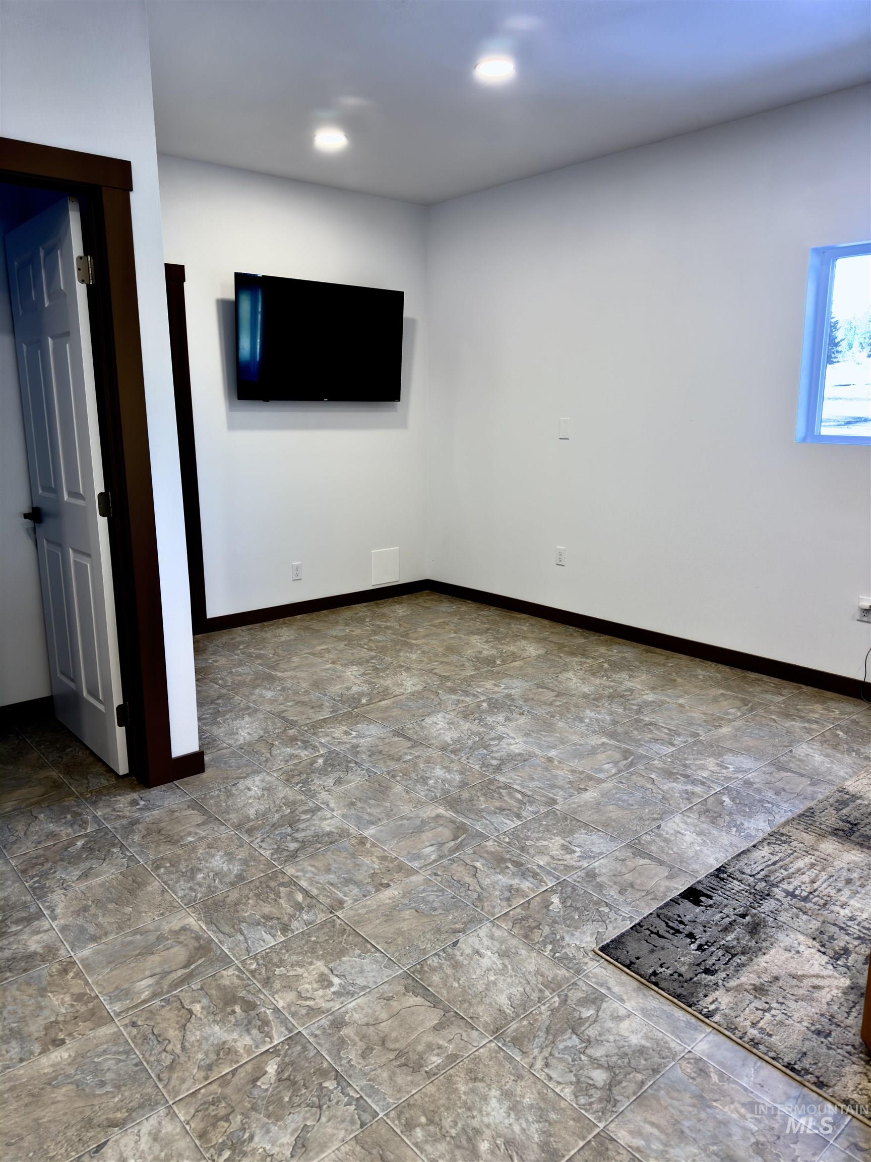 1112 Old Pk Road Deary, ID 83823 - Photo 13 of 23 Empty room featuring baseboards and light stone finish floors