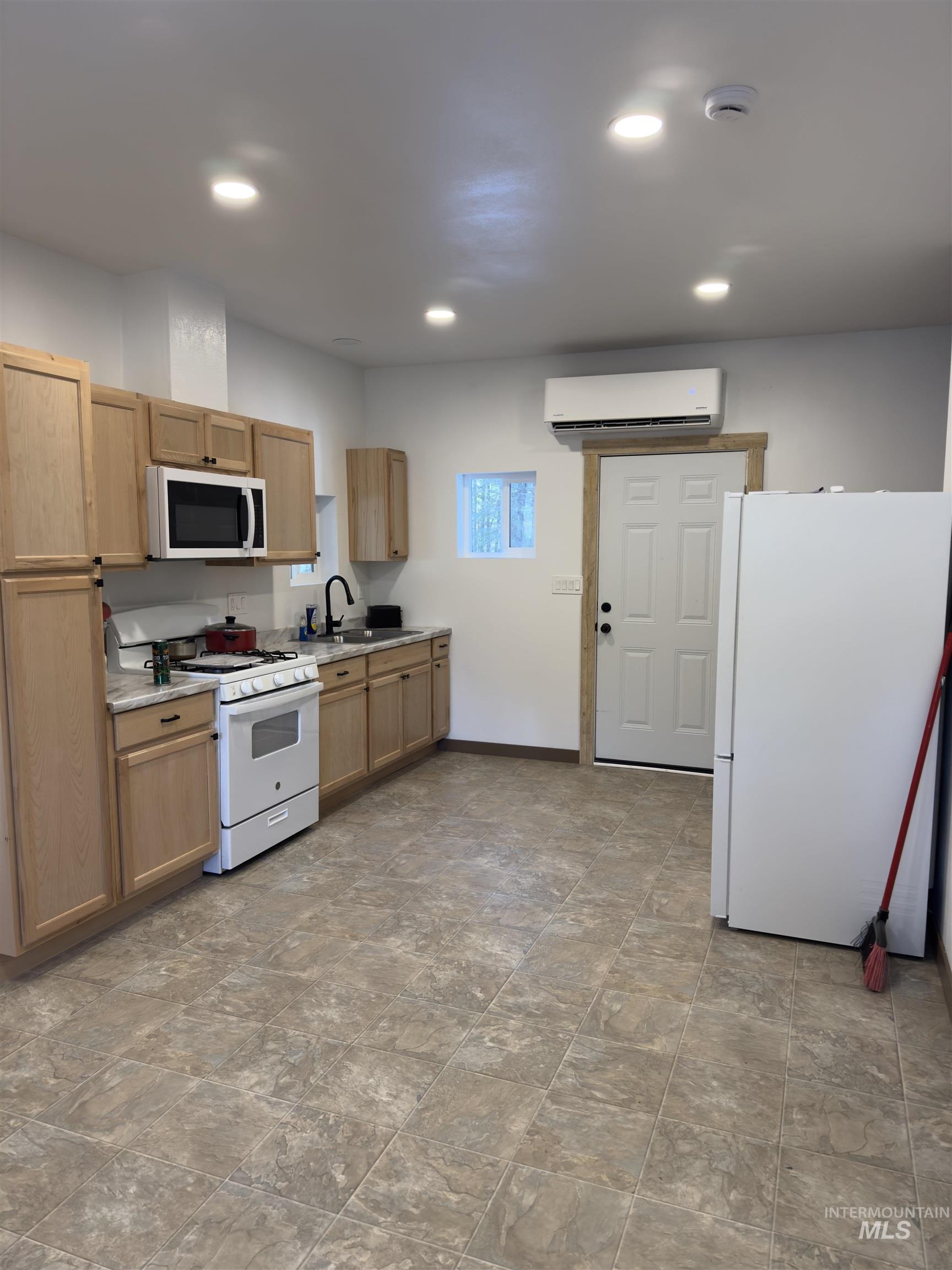 1112 Old Pk Road Deary, ID 83823 - Photo 19 of 23 Kitchen with white appliances, light countertops, stone finish floors, light wood finish cabinets, and recessed lighting