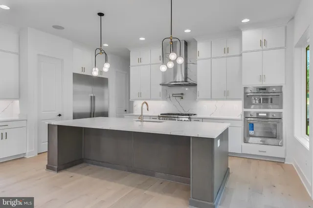 a kitchen with kitchen island a sink stainless steel appliances and cabinets