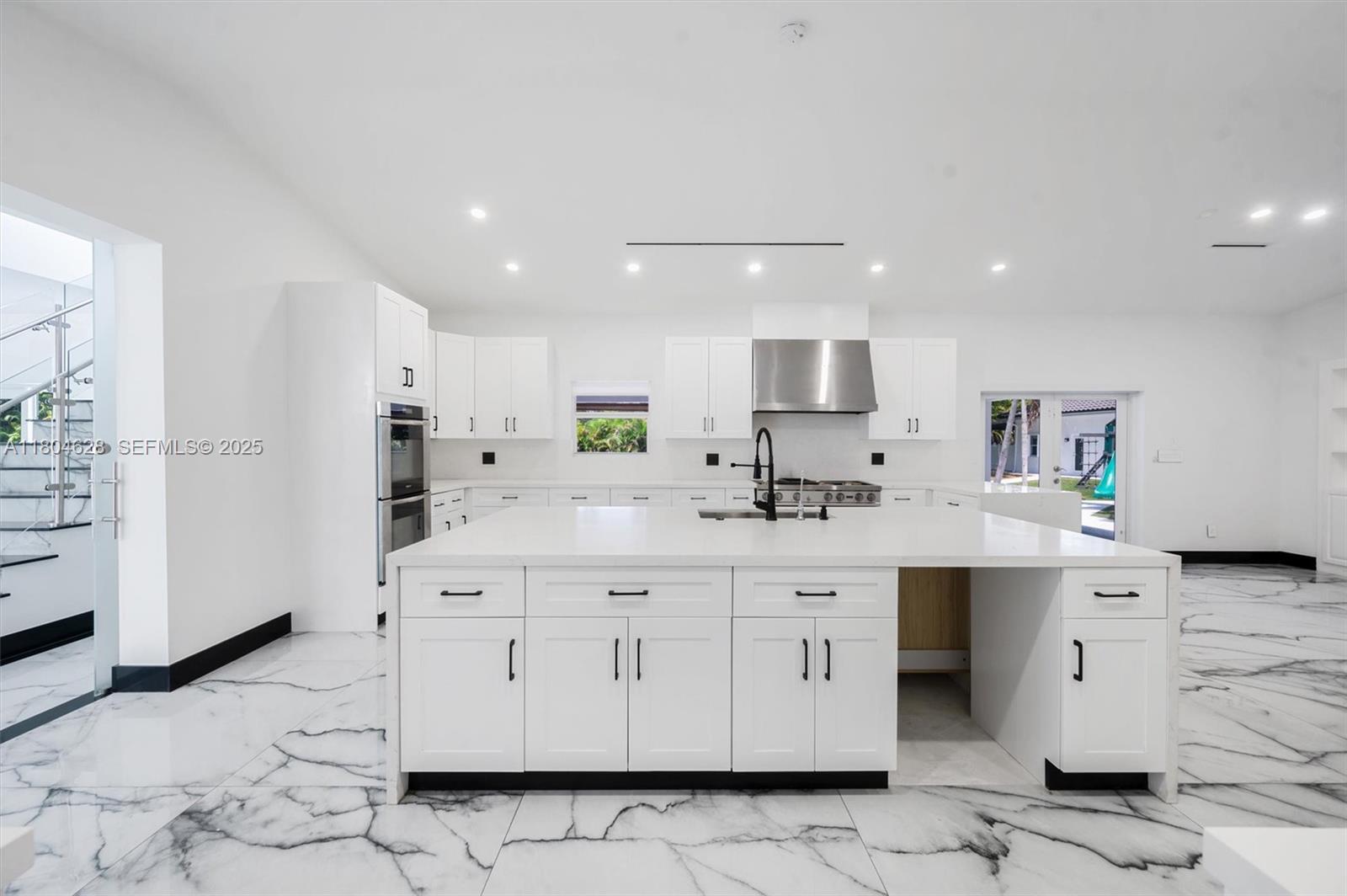 5121 Southwest 210th Terrace Southwest Ranches, FL 33332 - Photo 11 of 70 a kitchen with stainless steel appliances granite countertop a sink a stove a refrigerator and white cabinets