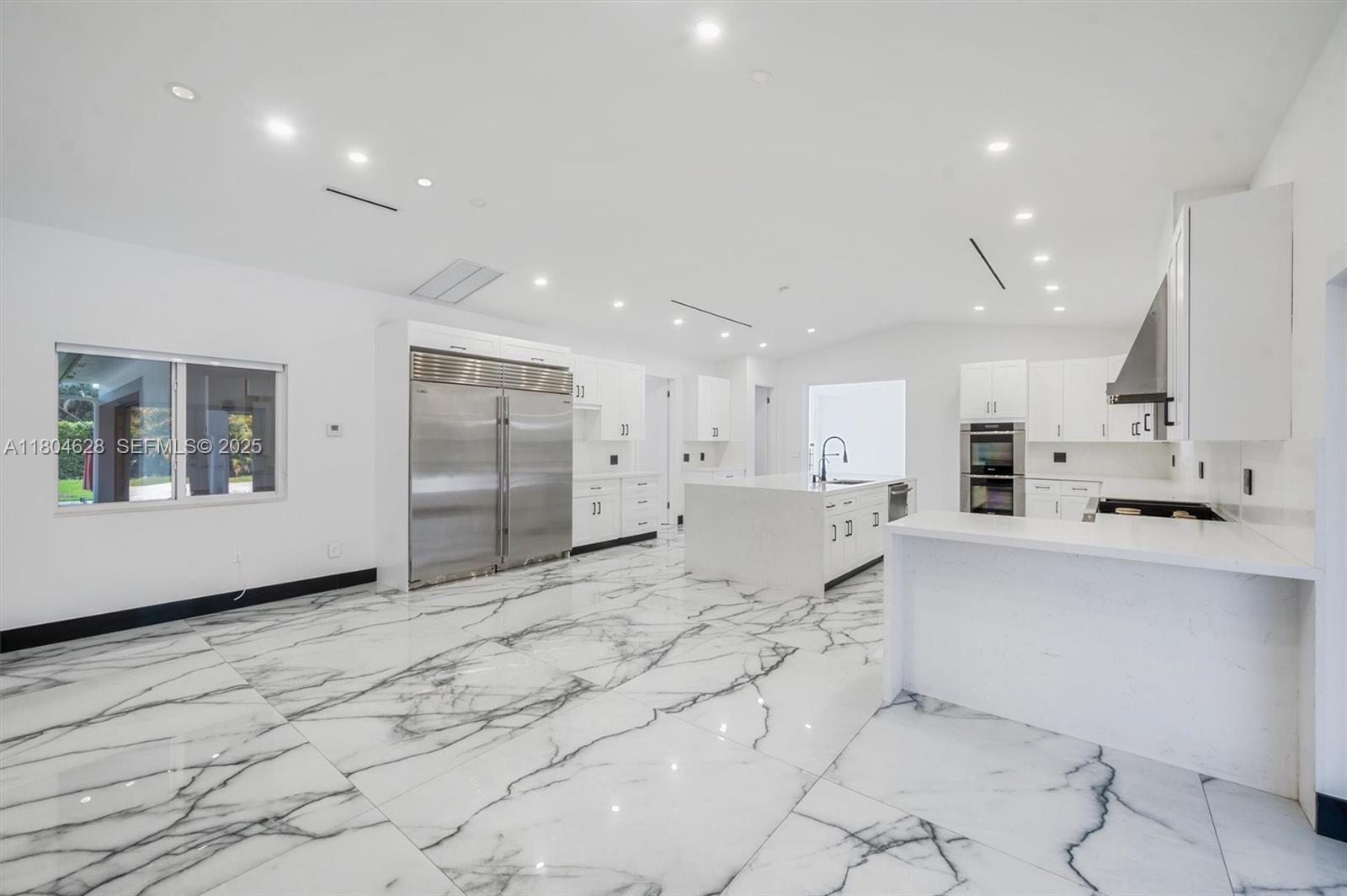5121 Southwest 210th Terrace Southwest Ranches, FL 33332 - Photo 13 of 70 a large white kitchen with kitchen island a sink stainless steel appliances and cabinets