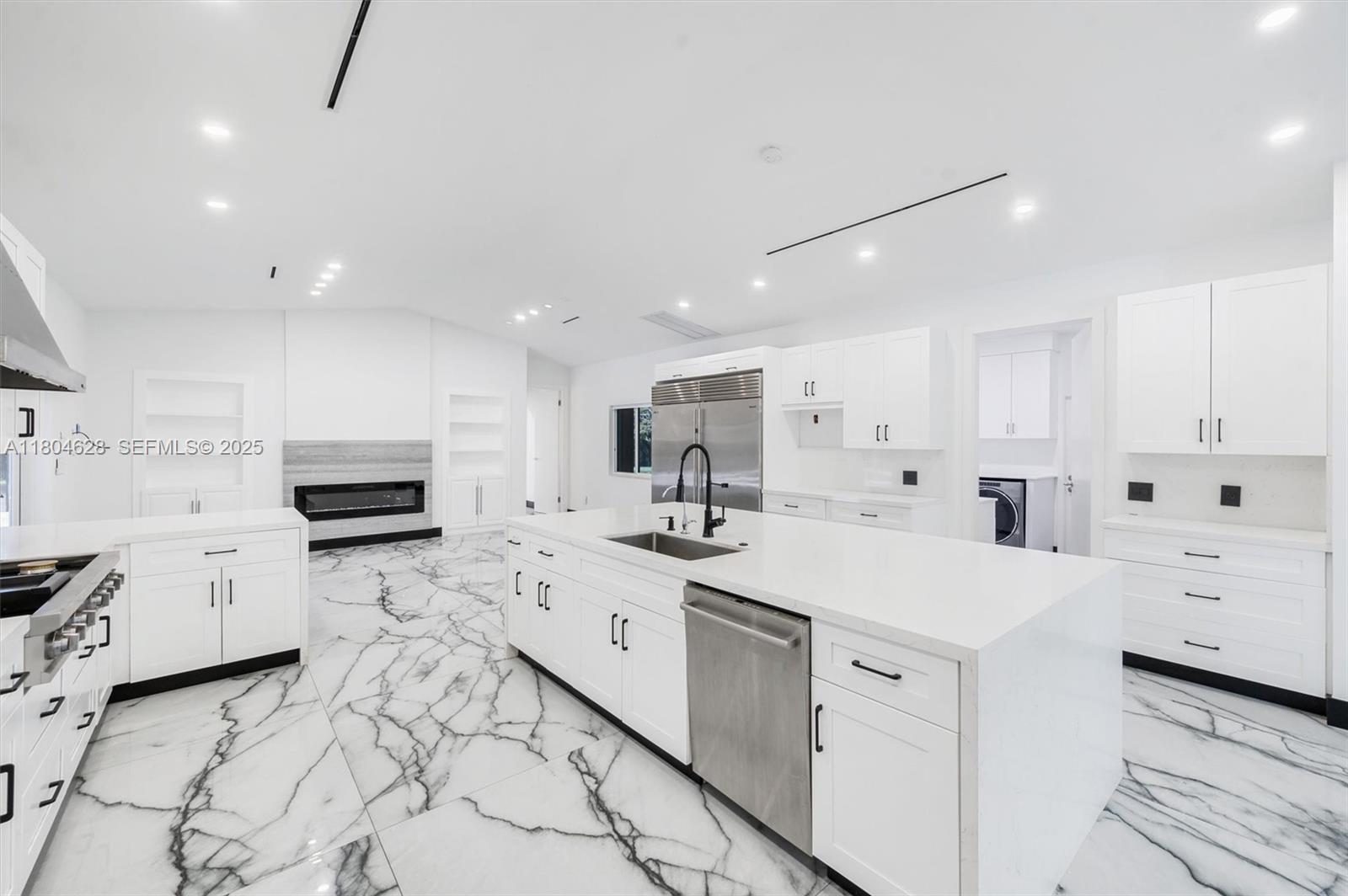 5121 Southwest 210th Terrace Southwest Ranches, FL 33332 - Photo 15 of 70 a kitchen with stainless steel appliances a sink a stove a microwave a refrigerator and cabinets