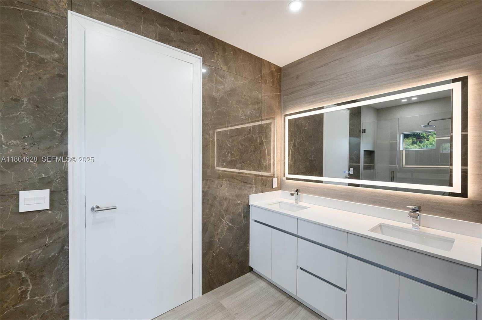 5121 Southwest 210th Terrace Southwest Ranches, FL 33332 - Photo 36 of 70 a bathroom with a sink and a large mirror