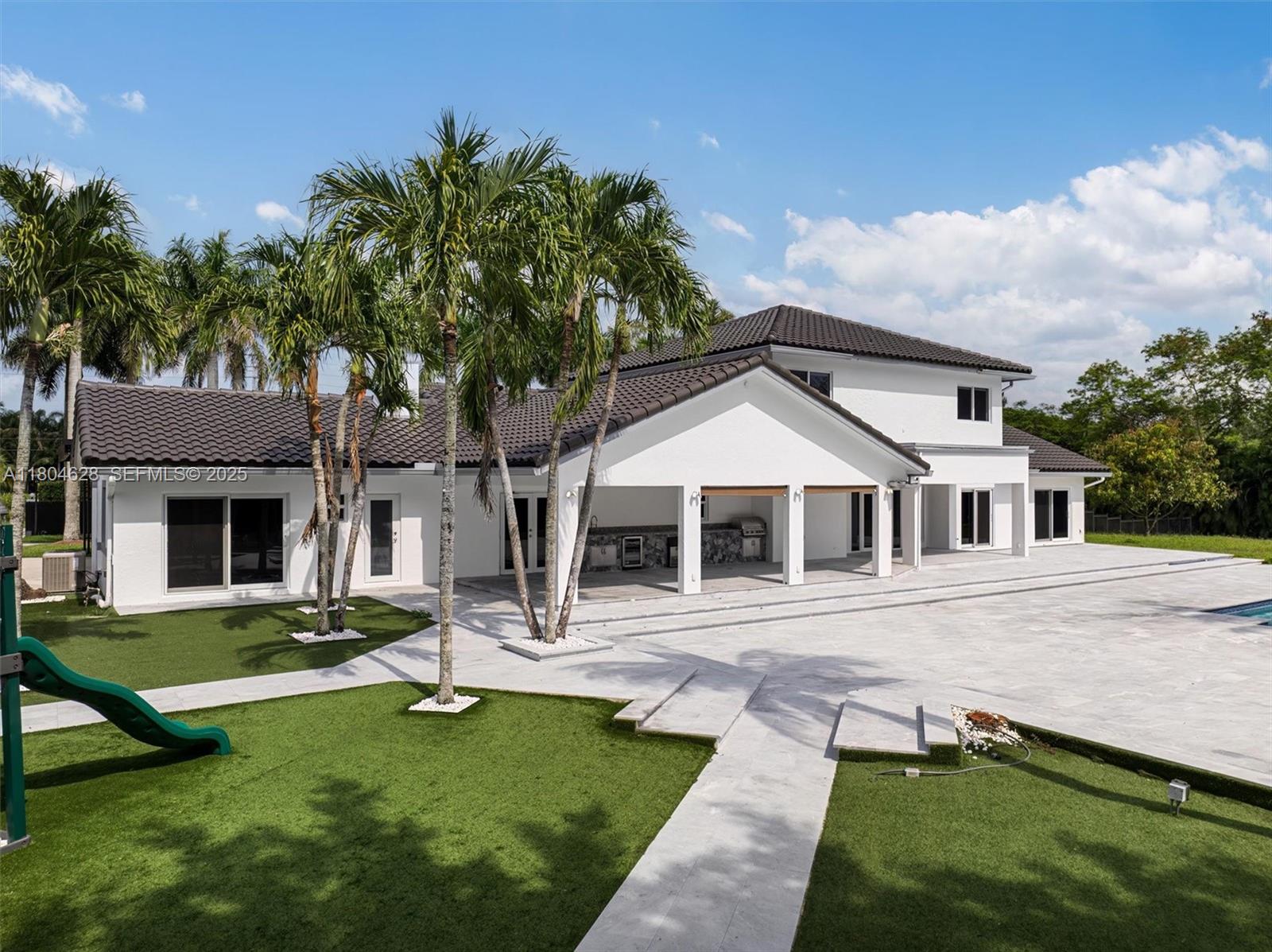 5121 Southwest 210th Terrace Southwest Ranches, FL 33332 - Photo 64 of 70 a front view of a house with a garden and trees