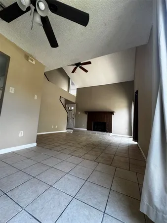 a room with a ceiling fan and a rug