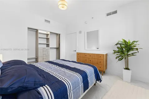 a bedroom with a bed and a potted plant