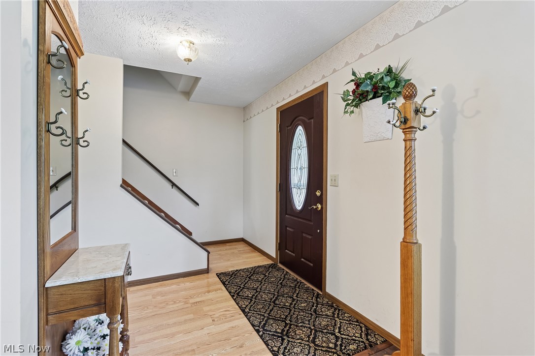 4702 Alger Road Richfield, OH 44286 - Photo 6 of 46 Front door entry featuring a door with oval glass insert, stairway to second floor and LVT flooring