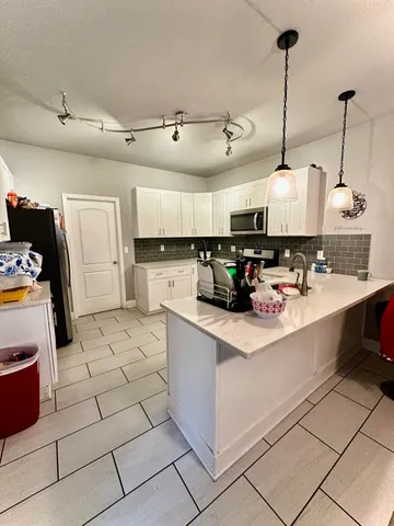 a view of kitchen with sink and refrigerator