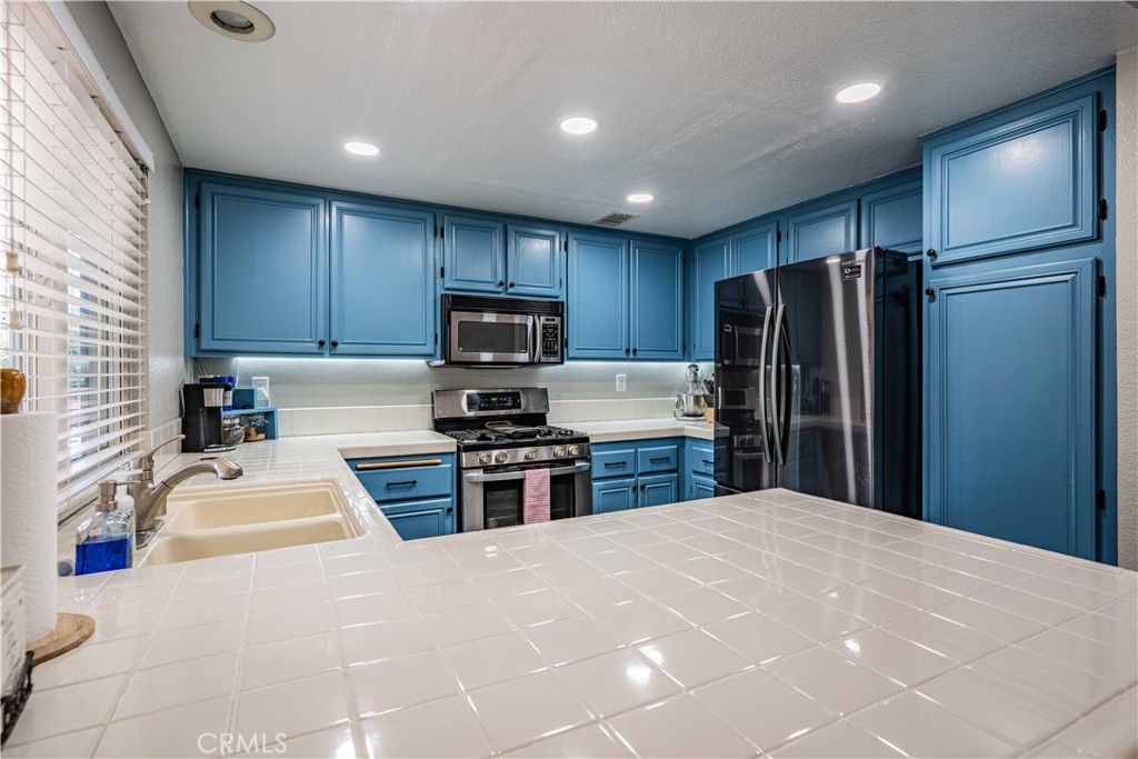 27571 Cabrillo Drive Menifee, CA 92586 - Photo 16 of 56 a kitchen with granite countertop a refrigerator stove and sink