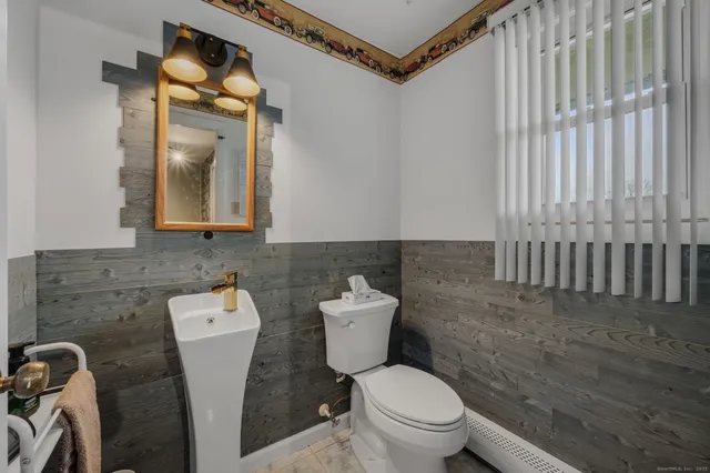 a bathroom with a toilet a sink and mirror