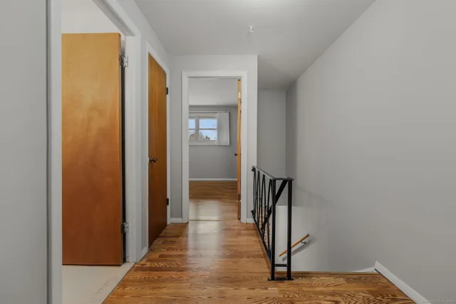 a view of a hallway with wooden floor and staircase