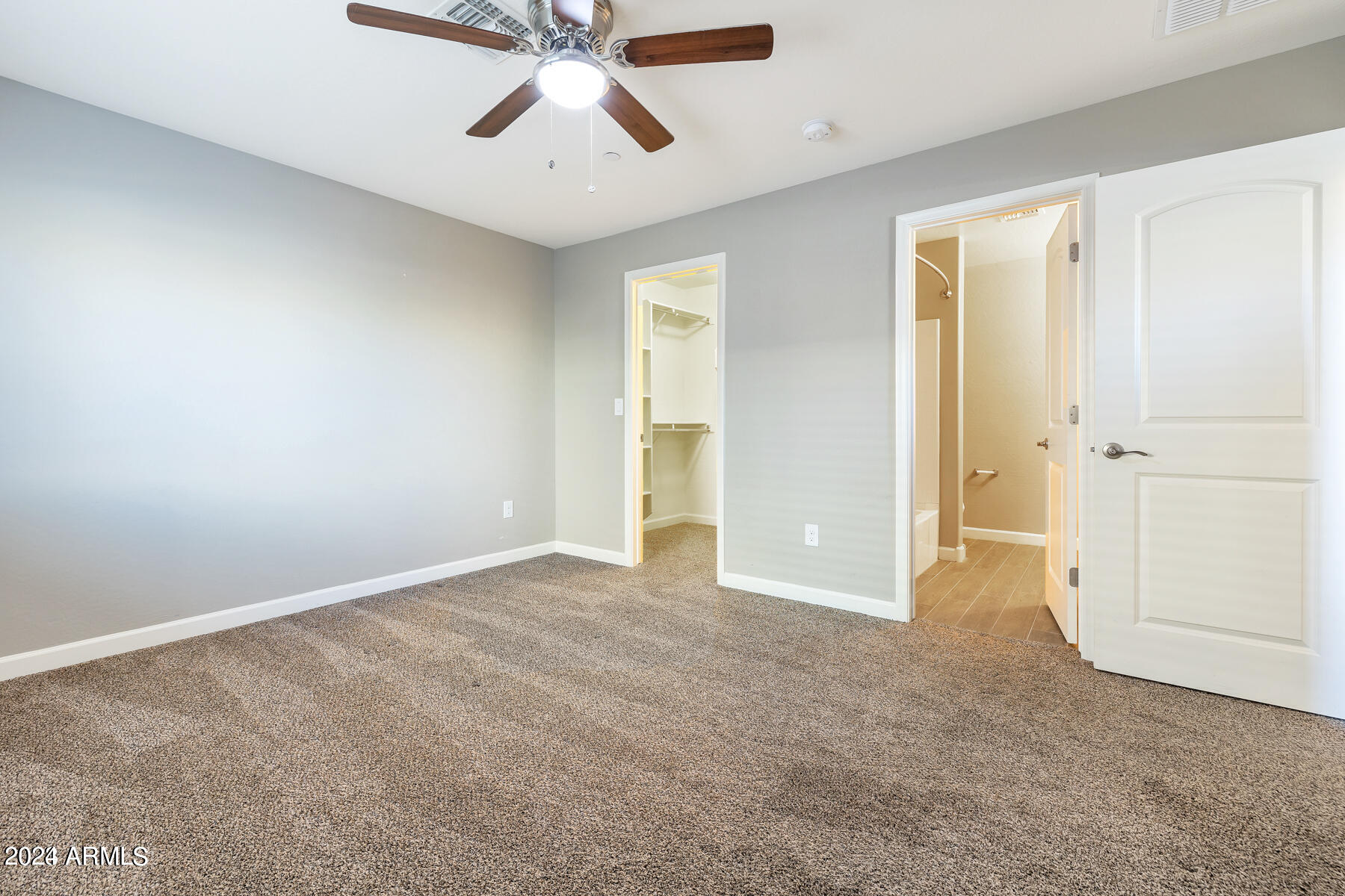 2150 West Alameda Road, Unit 1169 Phoenix, AZ 85085 - Photo 18 of 26 an empty room with chandelier fan and windows
